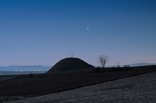 Sirius the Dog Star rising above ancient burial mound in Grossmugl, Austria