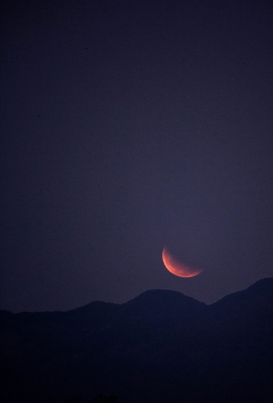 Blood moon rising above the mountains